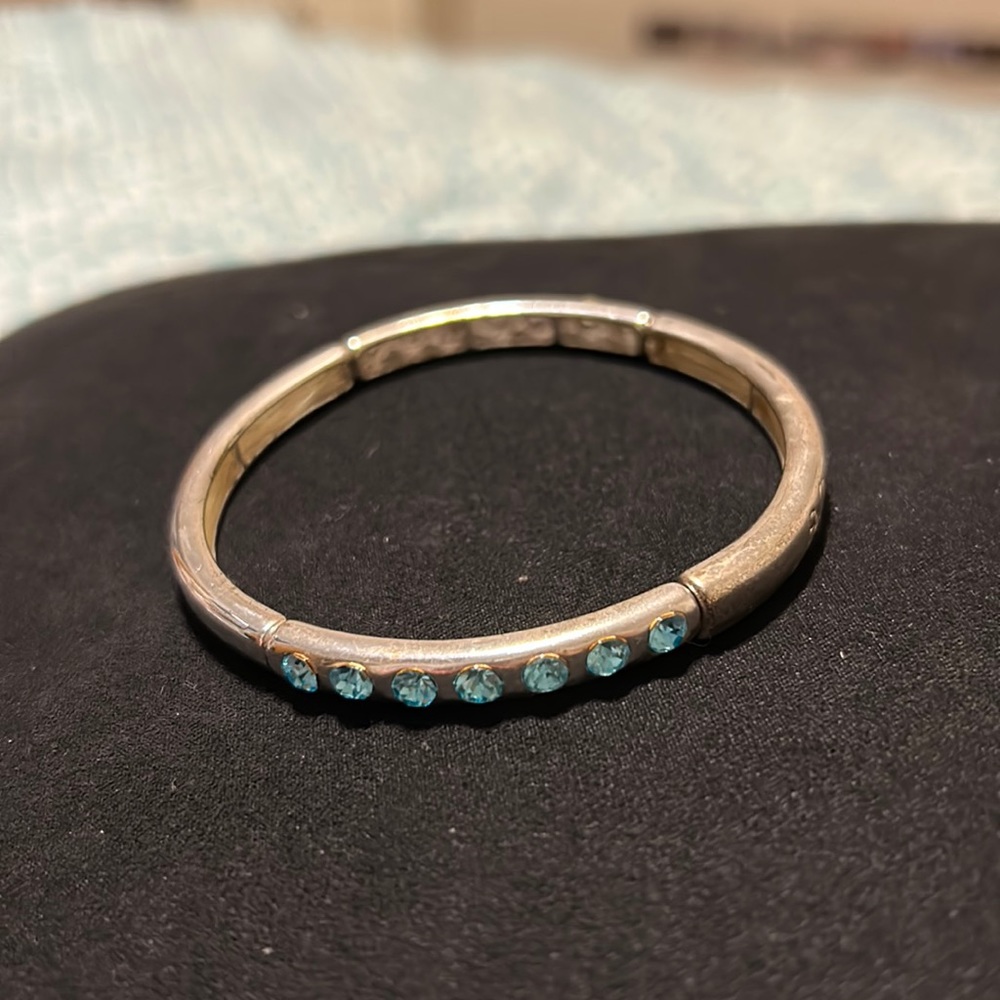 Kids silver bracelet with 7 blue rhinestones each side of bracelet. Gently used